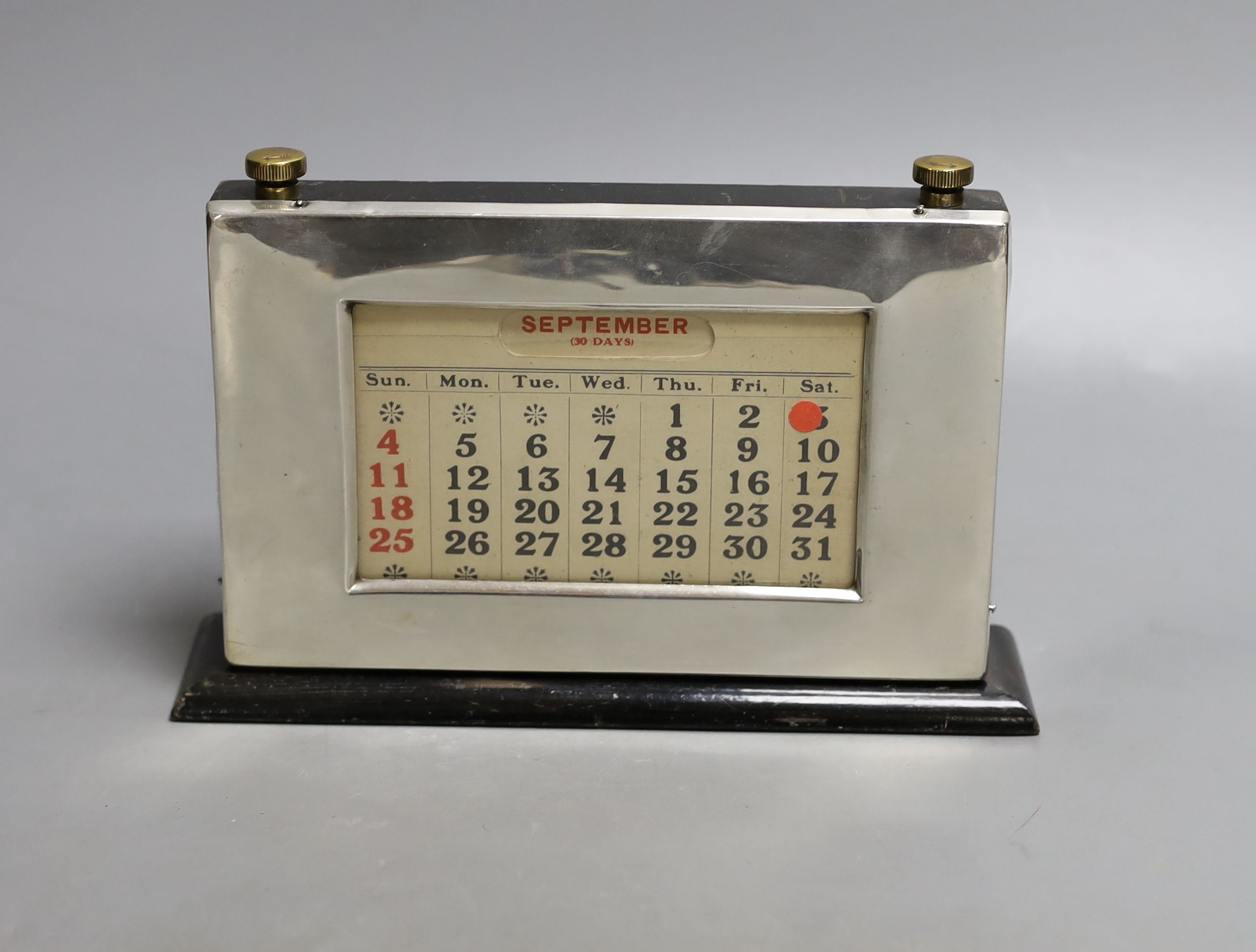 A modern silver mounted ebonised wood desk calendar, Birmingham, 1953, base 21.2cm.